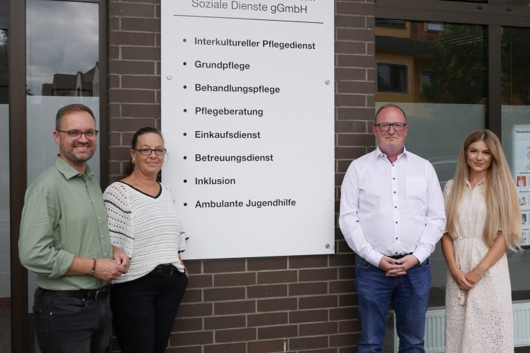 Kooperationsgespräch vor dem Standortschild des DRK-Pflegedienstes in Speyer