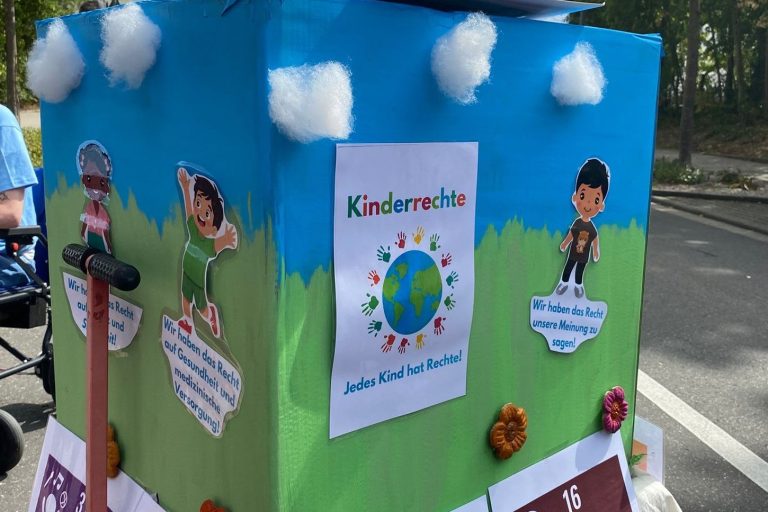 Geschmückter Wagen mit Schildern zu den Kinderrechten beim Festumzug zum Stadtjubiläum Germersheim
